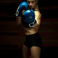 Woman in defense pose wearing Kruzak Blue boxing gloves