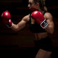 Woman in strike pose wearing Kruzak Red boxing gloves